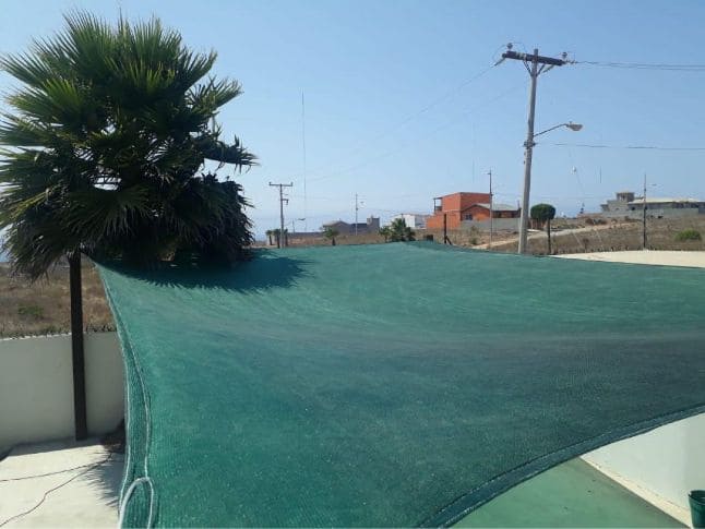 Malla sombra verde instalada en patio de casa en Tijuana